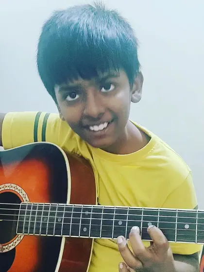 A happy student with his guitar. We believe that learning music should be a joyful experience, and this smile says it all.