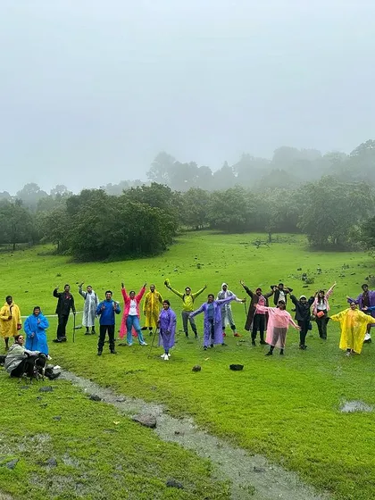 The Sharavathi batch of July 6th & 7th, posing in a lush green meadow. The vibrant colours of their raincoats stand out against the landscape.