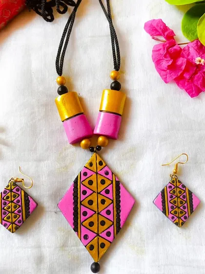 A sleek, daily-wearable set with a diamond-shaped pendant in pink and gold. The geometric patterns and simple chain make it perfect for office wear.