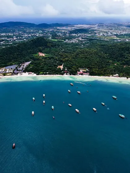 Aerials from Vietnam. A wide shot of the coastline, showing the beautiful beaches and lush green hills of this diverse country.