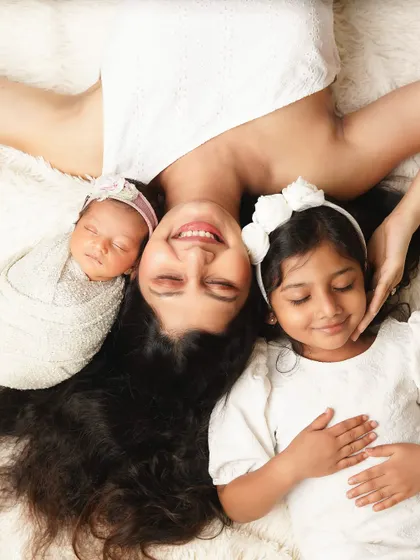 A creative overhead shot of a mother lying with her two daughters. This pose is playful and unique, creating a beautiful portrait of her life with her girls.