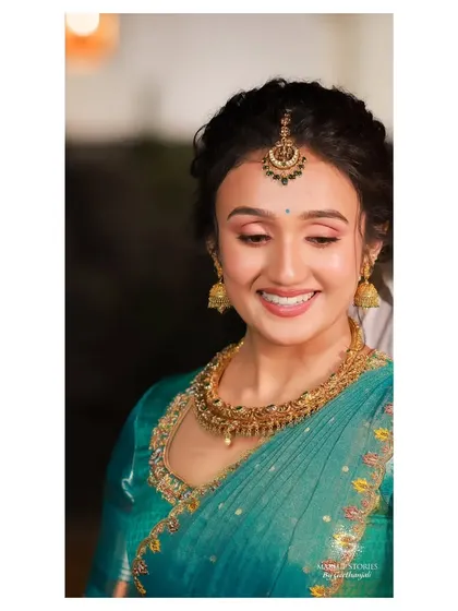 A happy, smiling portrait of Dr. Vishnu Priya. Her makeup looks fresh and radiant, capturing her joyful spirit and enhancing her natural glow.