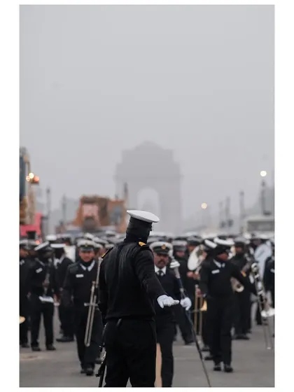 The Indian Navy contingent marches towards India Gate, which is faintly visible in the morning fog during parade rehearsals.