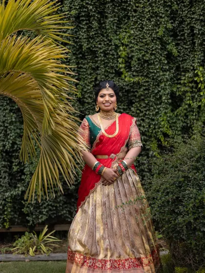 A full-length shot of this regal pre-wedding attire. The makeup is balanced to complement the rich colors and heavy embroidery of her outfit.