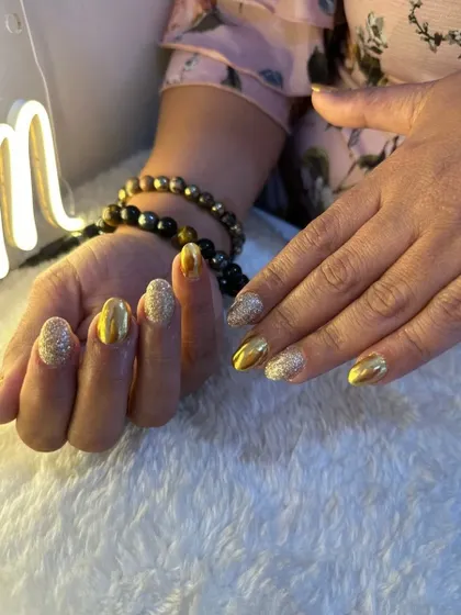 Another view of the gold glitter and foil nails, showing how they catch the light. This is a perfect look for any festive occasion.