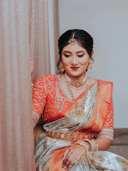 An elegant seated portrait of the bride, showcasing her stunning saree and jewelry in beautiful detail.