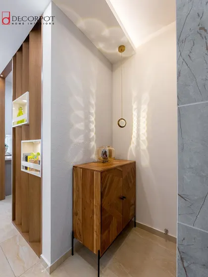 A minimalist corner unit in a natural wood finish. The simple design and chevron pattern on the door make it a subtle yet stylish addition to any room.