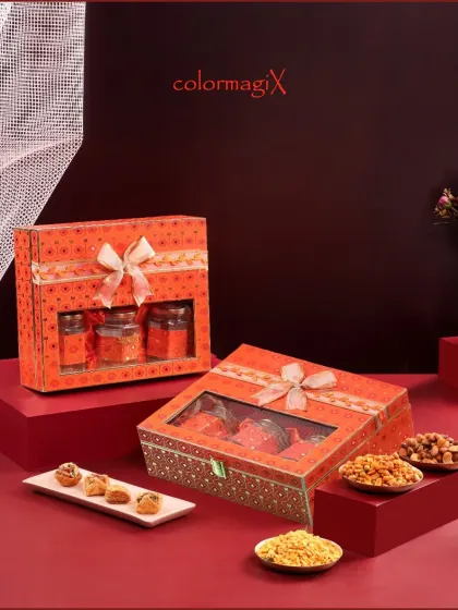 Our windowed gift boxes offer a preview of the festive treats inside. This matching set in a vibrant orange pattern is perfect for corporate orders, filled with gourmet snacks and sweets.