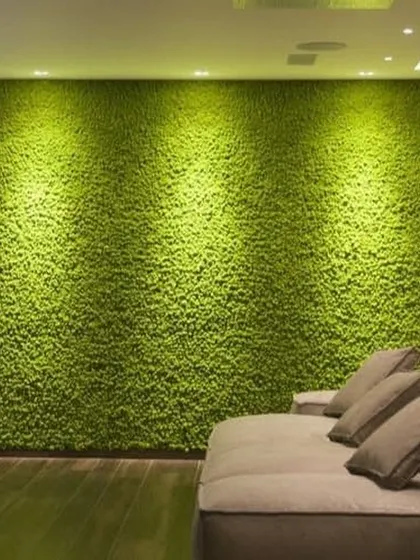 A full accent wall covered in artificial moss, creating a soft, vibrant, and sound-absorbing feature in this living room. The spotlights enhance the rich texture, making it a stunning focal point.