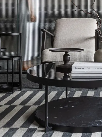 A closer look at the curated coffee tables in the waiting area. The mix of heights, materials, and shapes breaks up the space and allows the eye to travel, adding visual interest to the monochrome scheme.