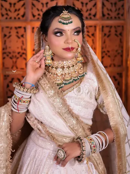 A three-quarter shot of the bride adjusting her earring. This candid-style pose adds a touch of natural elegance to the photoshoot.