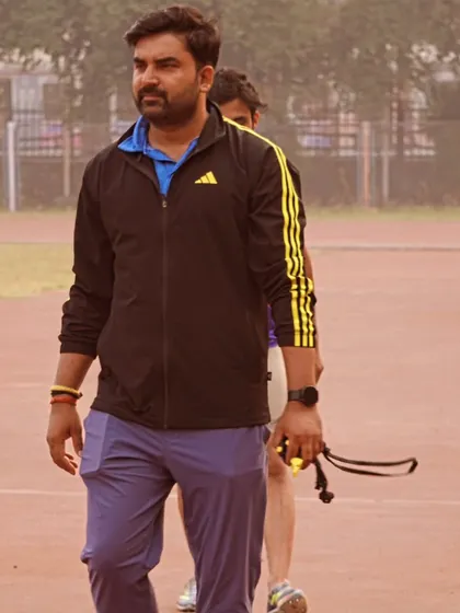 Focused on the track, observing my athletes during a training session.