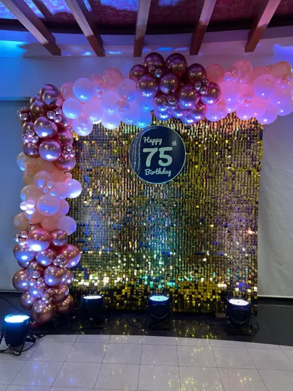 Celebrating 75 years with a dazzling gold sequin wall and a balloon arch in rose gold and pink. This setup is all about glamour and celebration.