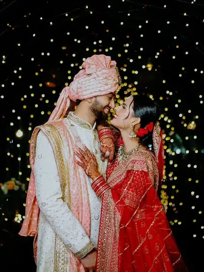 A romantic portrait of the couple under an arch of fairy lights, a perfect way to capture the magic of an evening wedding.