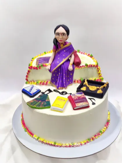 A custom cake to celebrate a 70th birthday, featuring a figurine of the woman and some of her favorite things, like her books and jewelry.