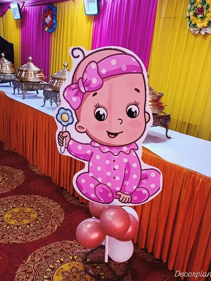 A cute baby girl cutout prop placed in the dining area of a baby shower. These small touches help tie the entire event space together and make every corner feel festive.