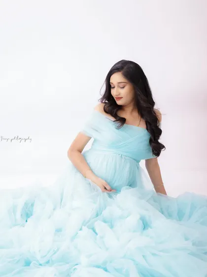 A duplicate of image 246, this portrait captures a serene moment with the mom-to-be seated in a cloud of light blue tulle.