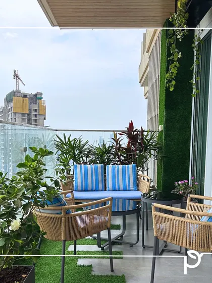 A comfortable seating area is essential for any balcony garden. Here, we've created an inviting space with outdoor furniture surrounded by lush plants, turning the balcony into a true outdoor living room.
