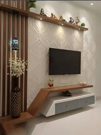 We used a 3D textured panel as the backdrop for this TV unit, adding depth and visual interest. The asymmetrical design with wood-finish shelves and a floating console is both modern and unique.