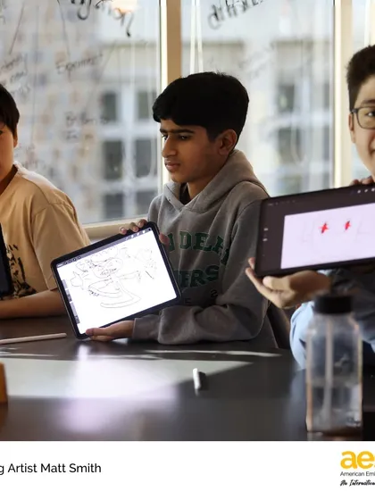 Students proudly display the characters they've designed on their tablets. Our visiting artist program integrates technology with traditional art forms, teaching modern creative skills.
