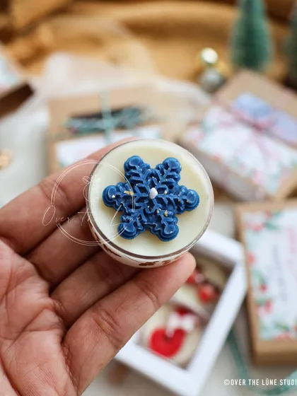 A close-up of the dark blue snowflake tealight. The glitter adds a beautiful, frosty sparkle.