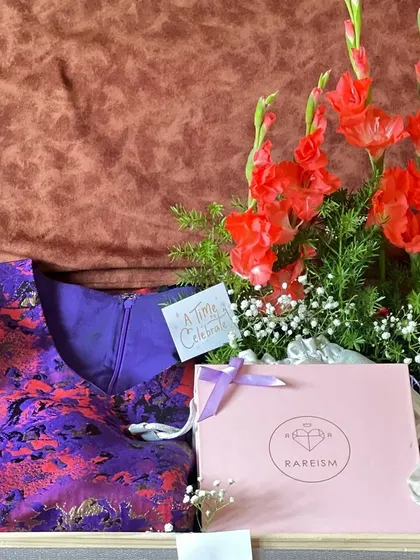 A wider view of the engagement hamper with a dress and fresh flowers. The combination of fashion, flowers, and thoughtful details creates a truly memorable gift.