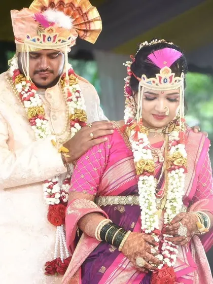 A tender moment between the couple during their wedding ceremony, captured in their beautiful pink and purple attire.