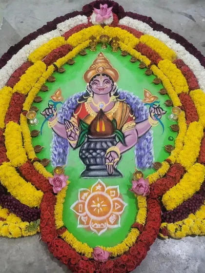 A beautiful rangoli of a Goddess, created with flowers and colored powders.