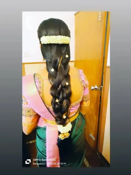 A long, flowing braid decorated with pearl accessories and a simple jasmine arrangement at the top.