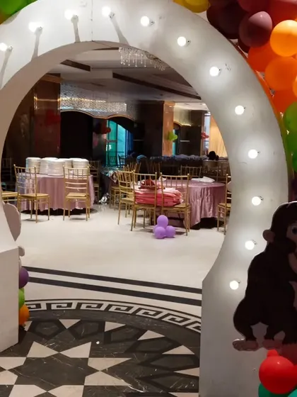 A light-up entrance arch for a jungle-themed party, with a monkey cutout to welcome guests.