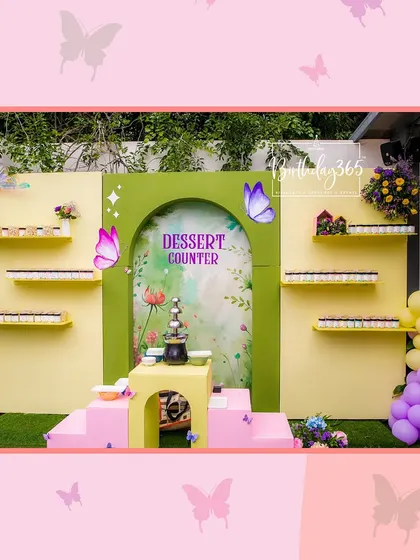 A custom dessert counter for a butterfly-themed party, set against a beautiful, artistic backdrop.