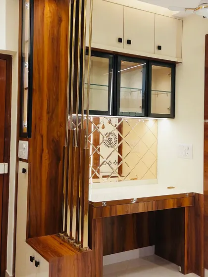 This crockery unit was designed to integrate seamlessly with the traditional decor of the living room. It features rich wood, mirrored accents with ethnic motifs, and glass shutters, blending modern storage needs with classic style.