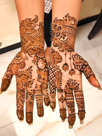 This Indo-Western design combines a bit of everything. It has a peacock, hanging bells (jhumki), and a mix of Indian and Arabic patterns for a truly unique look.