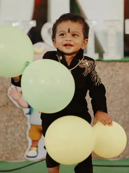 This little guy is ready for the party in his custom black bandhgala suit. The gold wing embroidery on the shoulder matches his dad's outfit, making them the most stylish duo in the room.