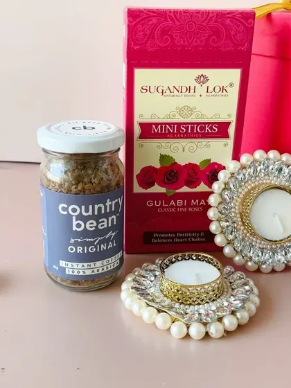 A close-up of some of the items in our budget-friendly round box hamper, including Country Bean coffee and pearl-decorated diyas.