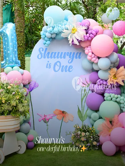 Shaurya's one-derful birthday. A beautiful pastel-themed first birthday setup, complete with a custom backdrop, balloon garland, and floral arrangements.