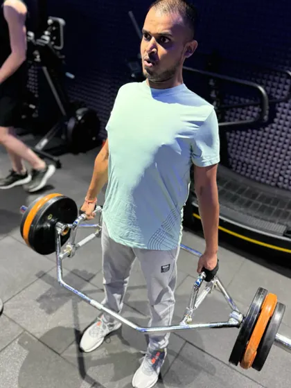 The trap bar deadlift is a fantastic alternative to the conventional deadlift, as it puts less stress on the lower back. This client is shown at the top of the movement, maintaining a strong, upright posture.