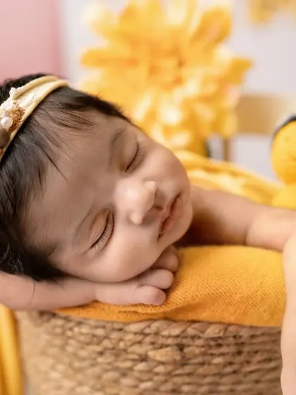 A close-up of this sleeping angel, resting her head on her hands in a basket. The warm yellow tones and tiny bee prop add to the "sweet as honey" theme.