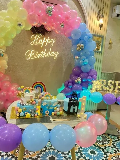 A closer view of the rainbow-themed cake table, showing the two beautiful cakes that match the colorful decorations.