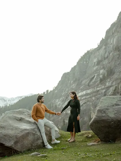 A quiet, posed moment amidst the rocks and mountains of Manali. This shot has a calm, editorial feel, showcasing the couple's connection in a serene setting.