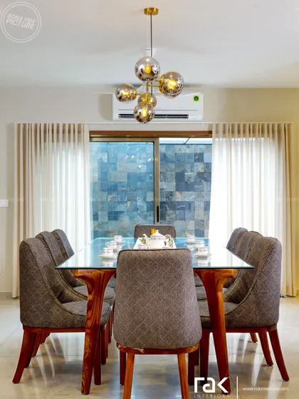 Another angle of the elegant dining room, showing how the large windows and sheer curtains create a bright and airy atmosphere.