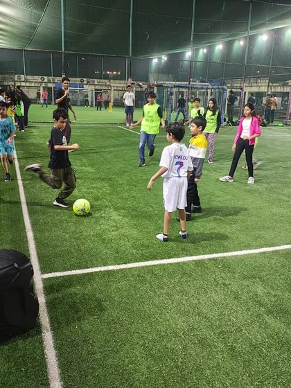 Even on the sidelines, the game is on! Kids practicing their kicks and moves at a football party.