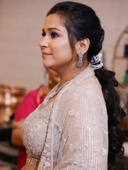 A side view of an elegant party hairstyle and makeup. The soft, glowing makeup is paired with a voluminous ponytail, creating a chic and modern look for any celebration.