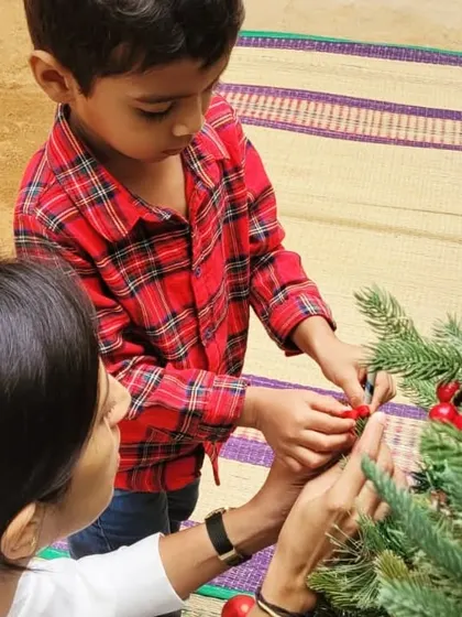 A helping hand for a young child during our Christmas celebrations. These shared activities are a beautiful way for children to learn about culture, community, and the joy of giving.