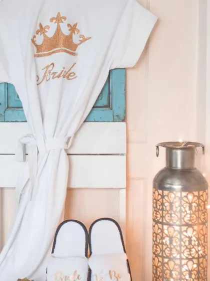 I offer personalized bridal robes and slippers for the bride and her crew. This white robe features a gold crown and "Bride" embroidery, making for great getting-ready photos on the wedding day.