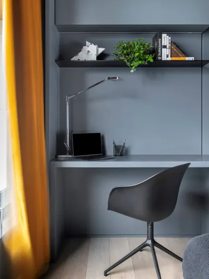 The integrated study desk in the son's bedroom, continuing the room's clean lines and grey color scheme.