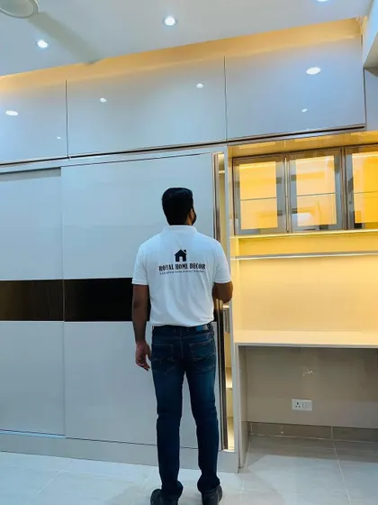 A sliding wardrobe with a built-in study nook. The design includes overhead cabinets with glass doors and under-shelf lighting, creating a perfect spot for work or study.