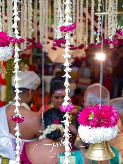 Another beautiful close-up of the wedding ceremony, with the intricate floral and bell decorations creating a stunning frame for the couple's union.