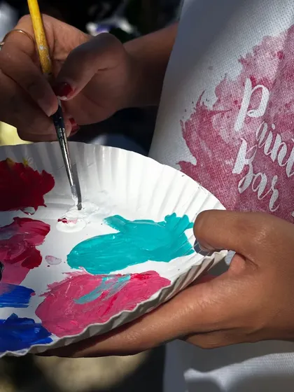 A close-up of our branded apron and a palette of fresh paint. We provide everything you need for a creative and fun experience.