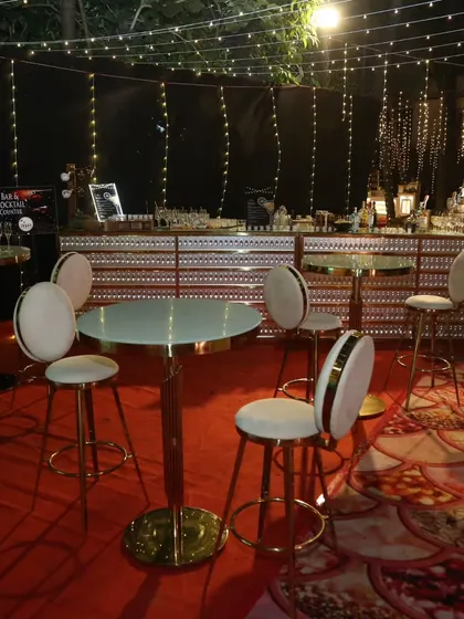 A sophisticated bar and cocktail lounge area we designed. The setup includes a beautifully lit main bar, high-top tables, and comfortable bar stools, creating a perfect space for guests to mingle.